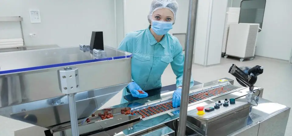 a young woman working at the roller conveyor line in a sterile room